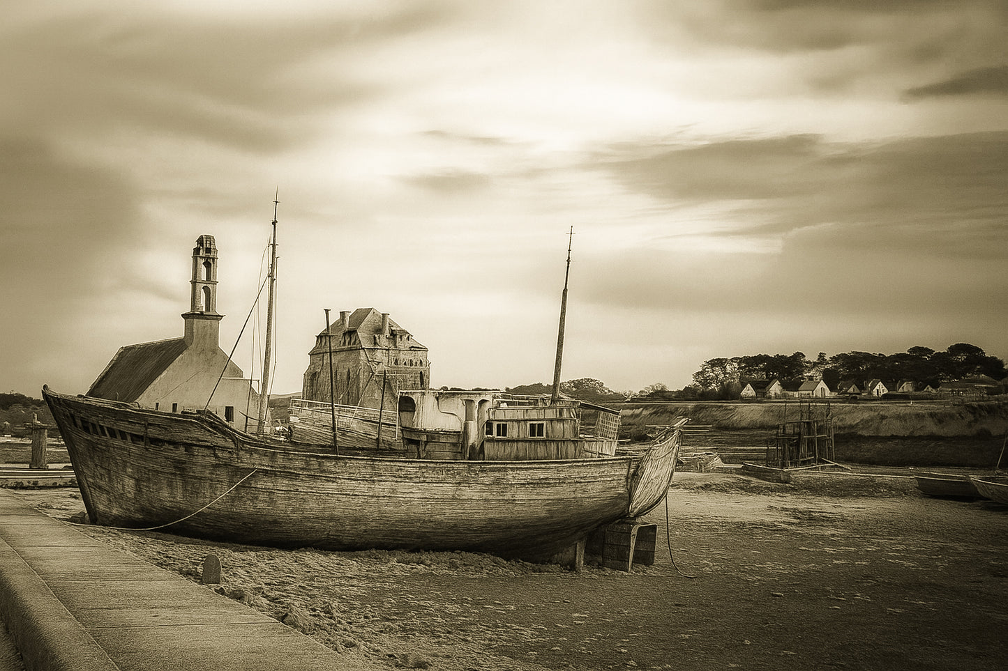 Épave bleue au premier plan devant chapelle et maisons, ciel doré au-dessus du port de Camaret, vintage