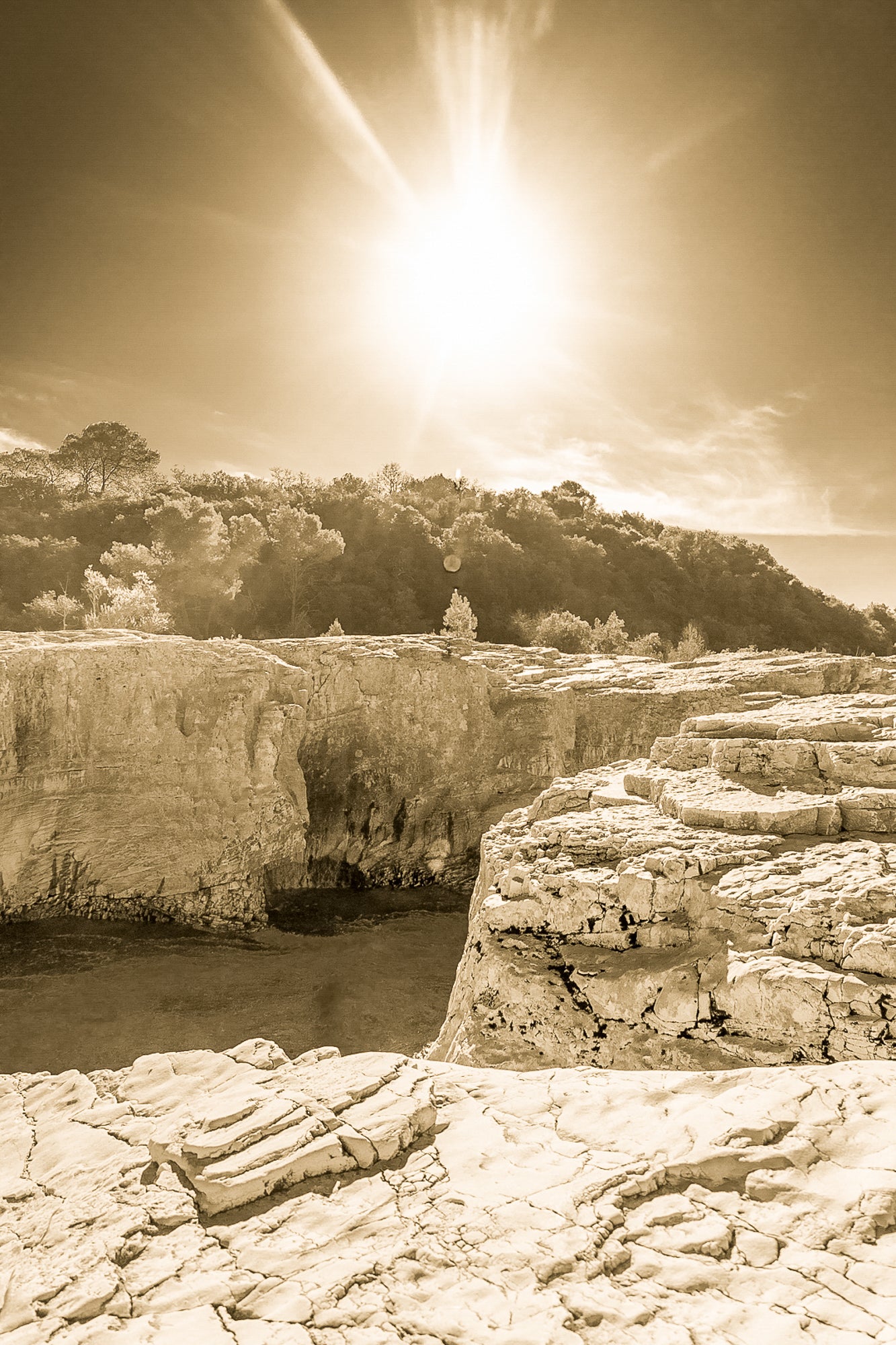 Soleil au zénith au-dessus des falaises claires et de l’eau bleu profond à la cascade du Sautadet, vintage