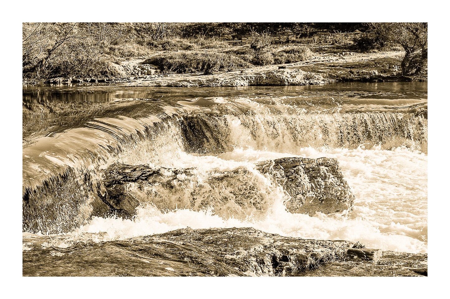Chute de la cascade du Sautadet vue de près, rideau d’eau doré glissant sur la roche avant de se briser en écume blanche, vintage avec bordure