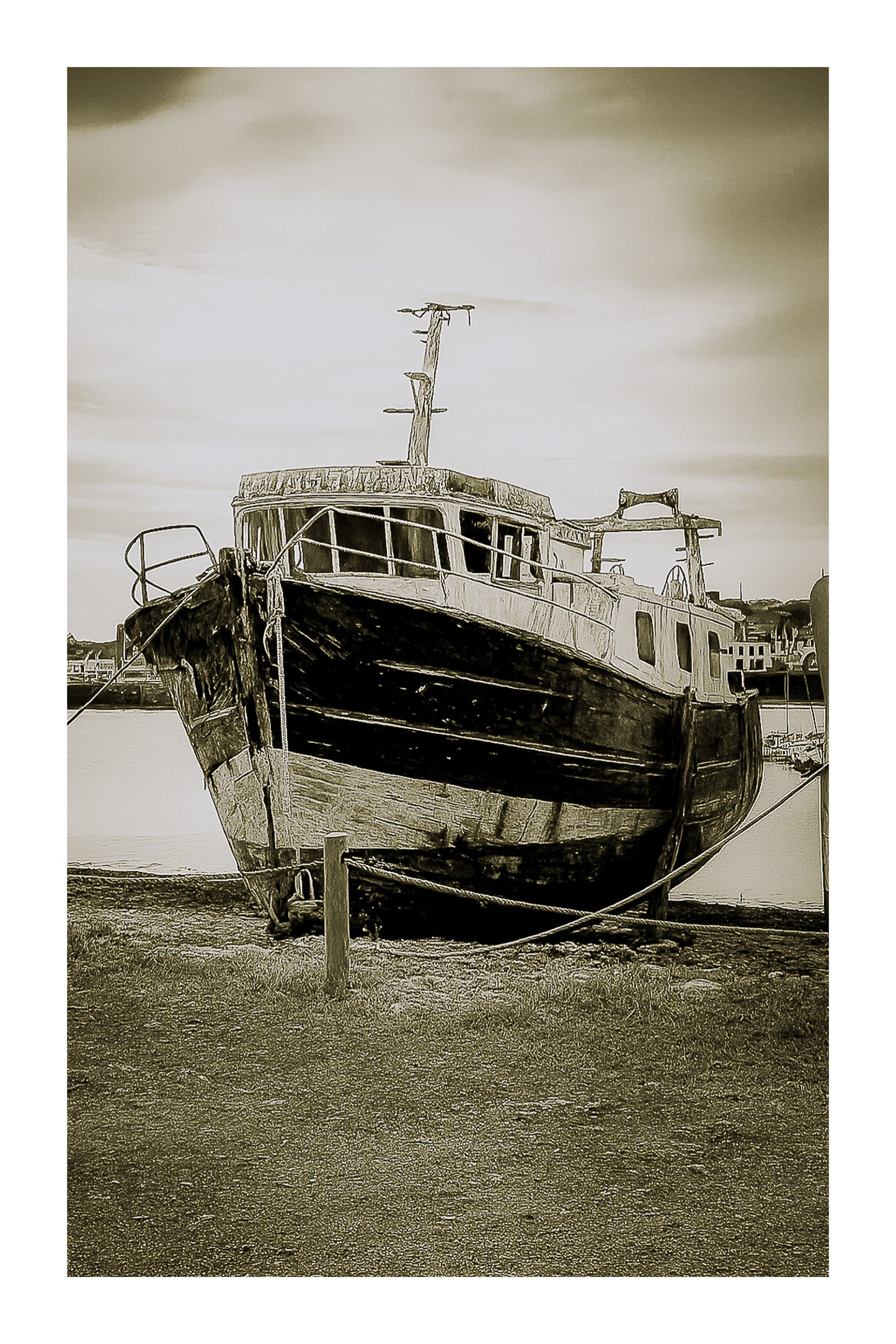 Épave au nez bleu et blanc amarrée par des cordes sur l’estran, ciel couvert au port de Camaret, vintage avec bordure