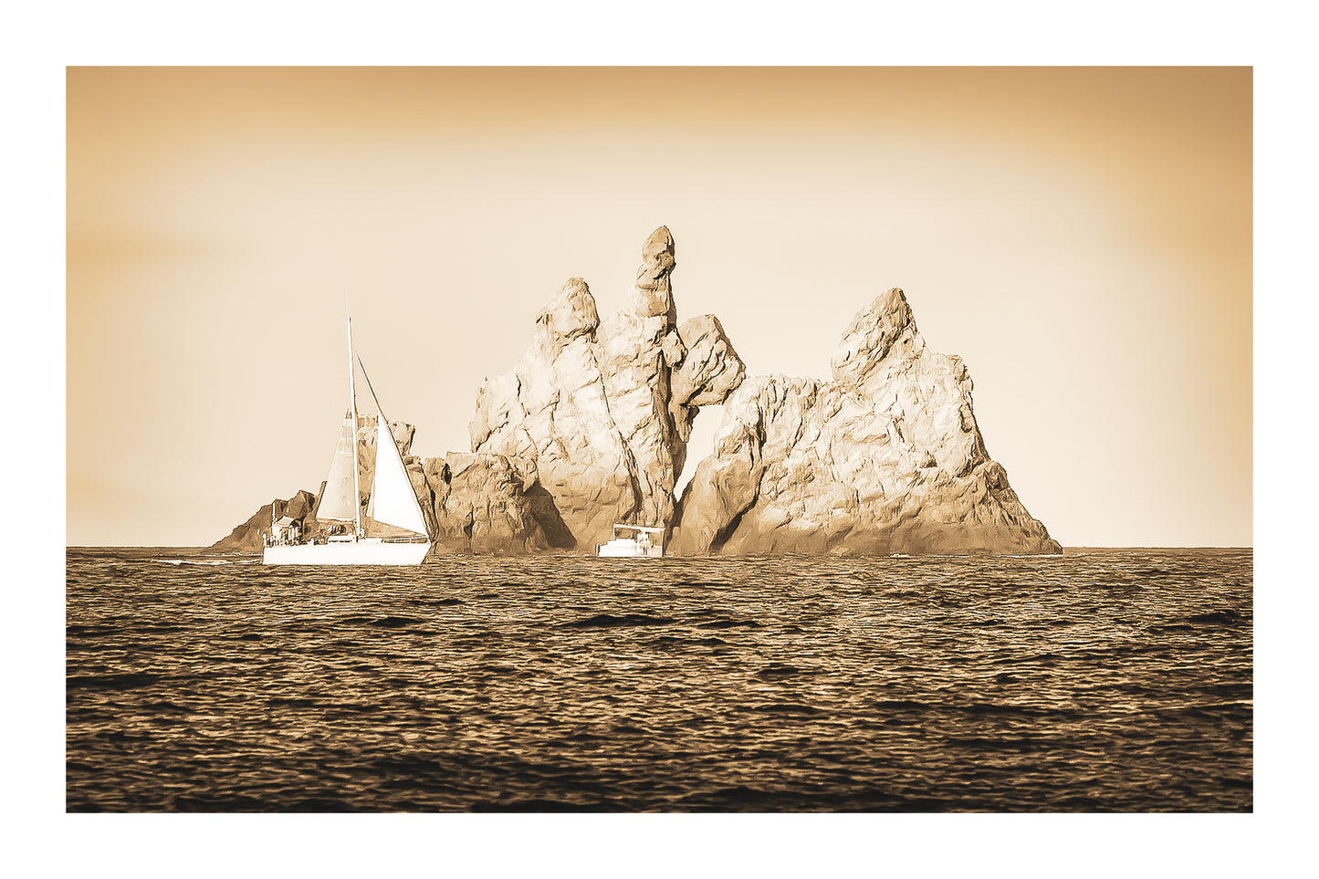 Voilier longeant un massif rocheux percé d’une arche en Méditerranée, lumière rasante de fin de journée, vintage avec bordure