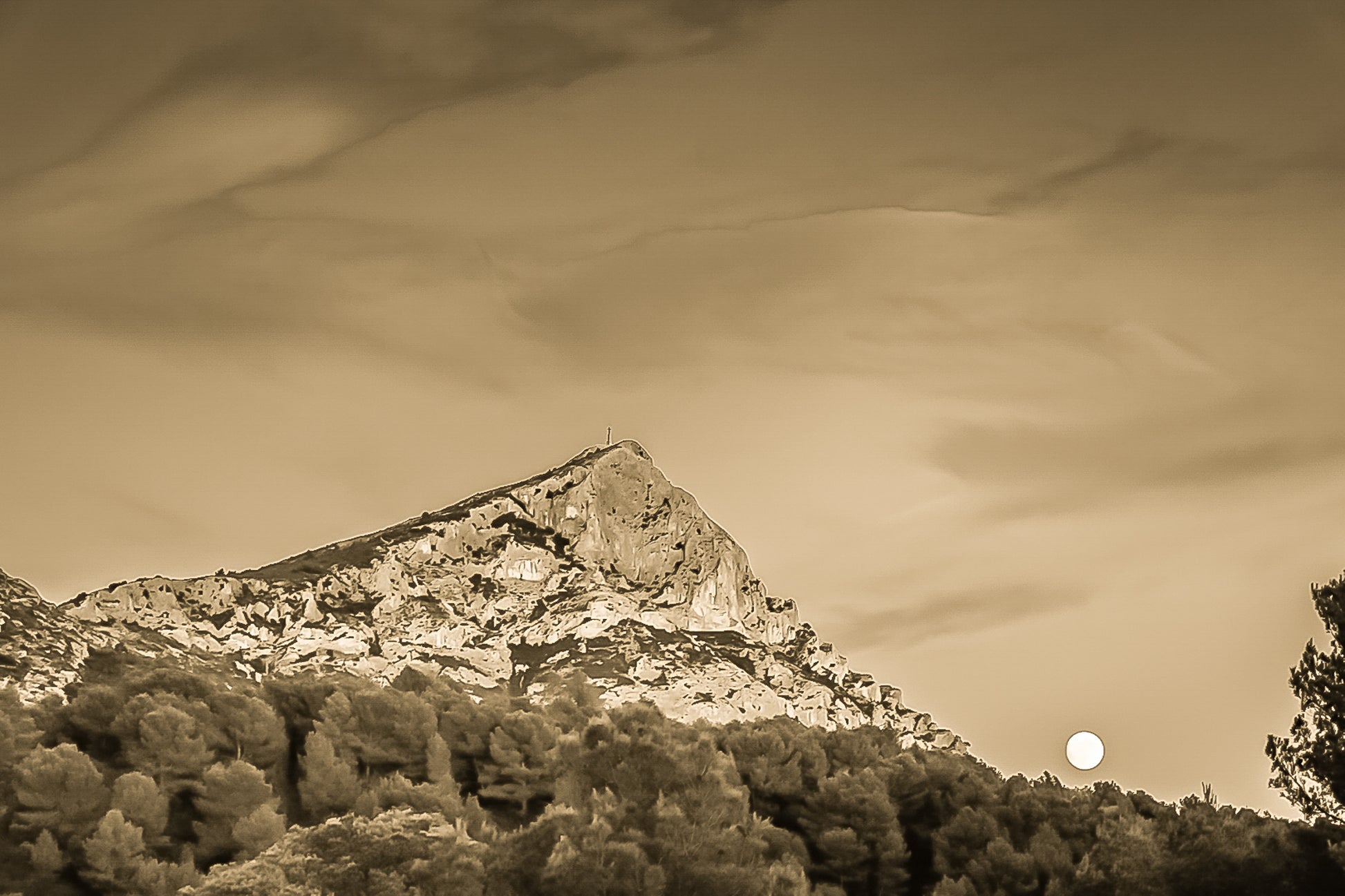 Lune jaune se levant près de la montagne Sainte-Victoire, ciel bleu aux nuages roses, pins en premier plan au crépuscule, vintage