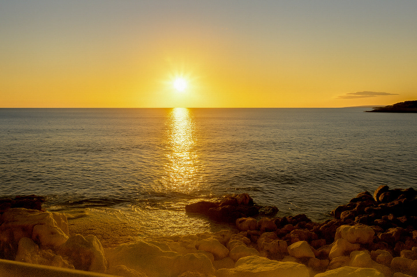 coucher de soleil à Carry-le-Rouet avec reflet doré sur la mer et premiers plans rocheux