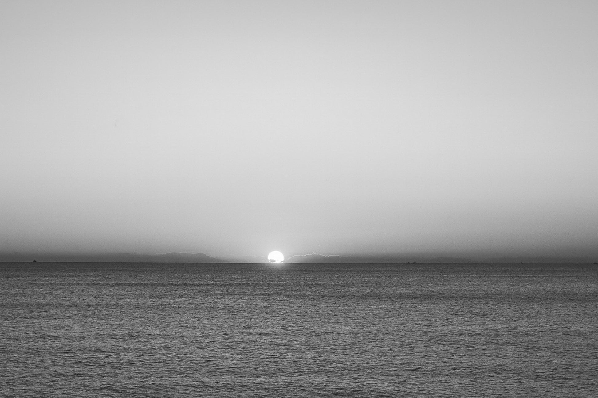gros plan de l’astre couchant à l’horizon marin, ciel orange à Carry-le-Rouet, noir et blanc