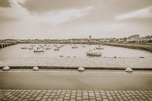Port de Roscoff en traitement sépia, pavés au premier plan, barques au mouillage et môle au loin