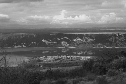 Village provençal posé au bord du lac de Sainte-Croix, falaises et reflets dorés sur l’eau calme, noir et blanc