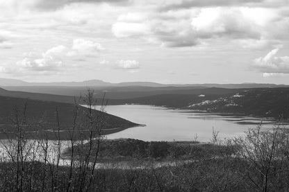 Long bras du lac de Sainte-Croix s’étirant entre collines et bosquets, sous un ciel nuageux, noir et blanc