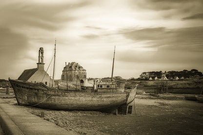 Épave bleue au premier plan devant chapelle et maisons, ciel doré au-dessus du port de Camaret, vintage