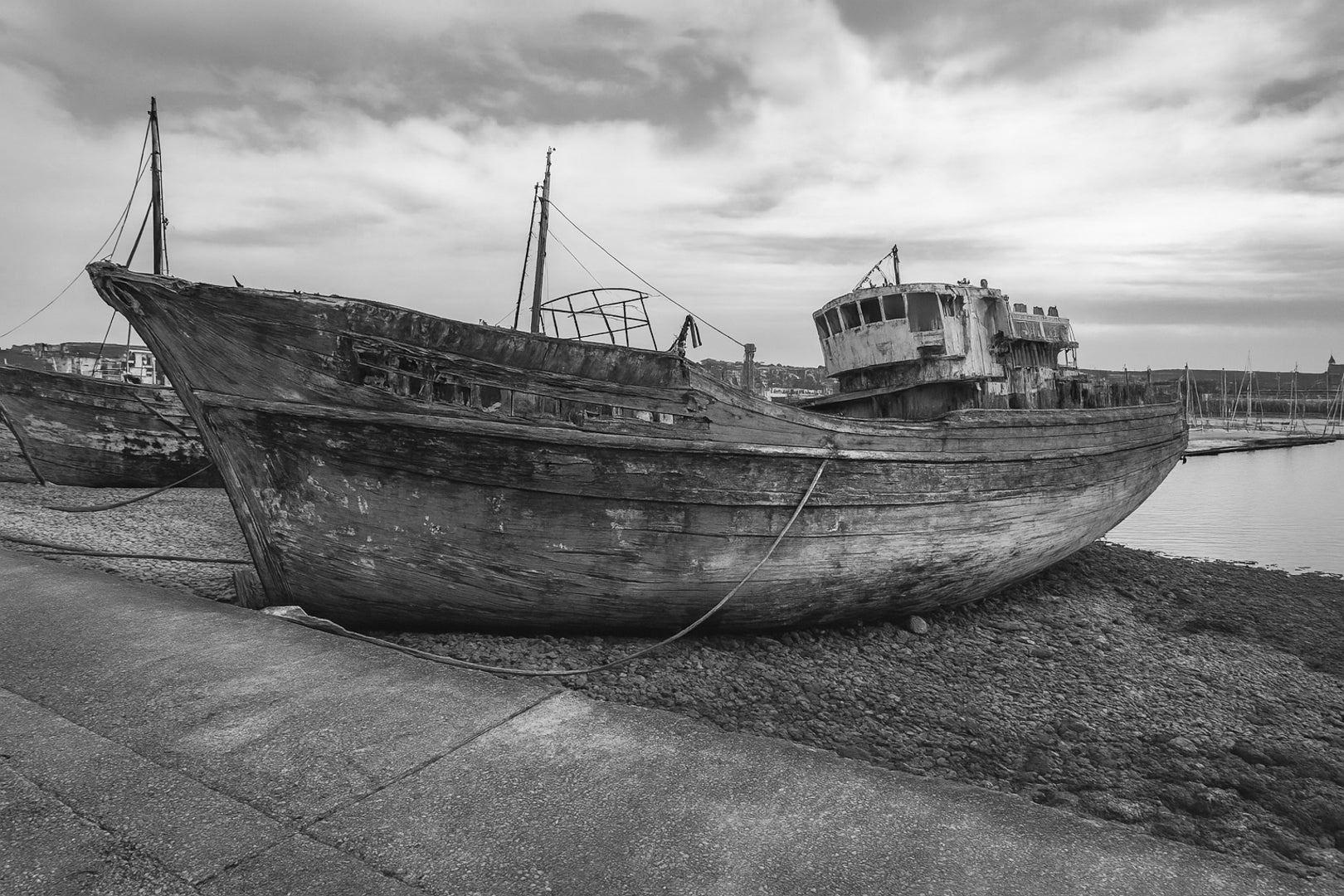 Grand chalutier rouillé échoué à marée basse, coque bleue écaillée, port de Camaret, noir et blanc