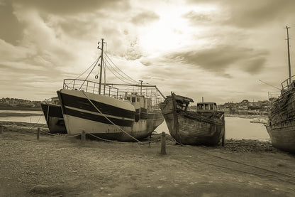Bateau plus récent sur la gauche et coque déchiquetée à droite sur la grève de Camaret, ciel lumineux, vintage