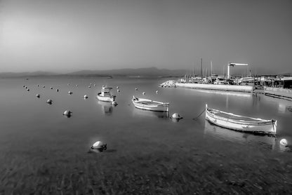 Barques au mouillage face au quai et aux mats du port du Brusc, fin de journée, noir et blanc 