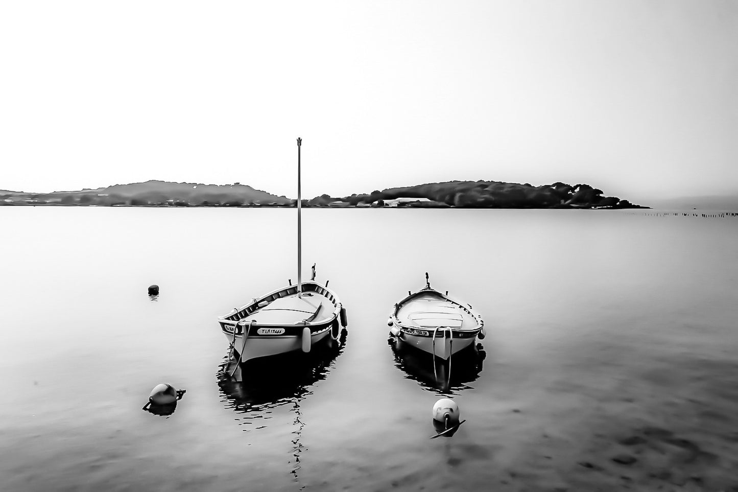 Deux barques côte à côte sur eau calme, îles au loin, douceur de soirée au Brusc, noir et blanc