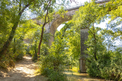 Viaduc de pierre traversant une vallée boisée au-dessus de la rivière de l’Arc