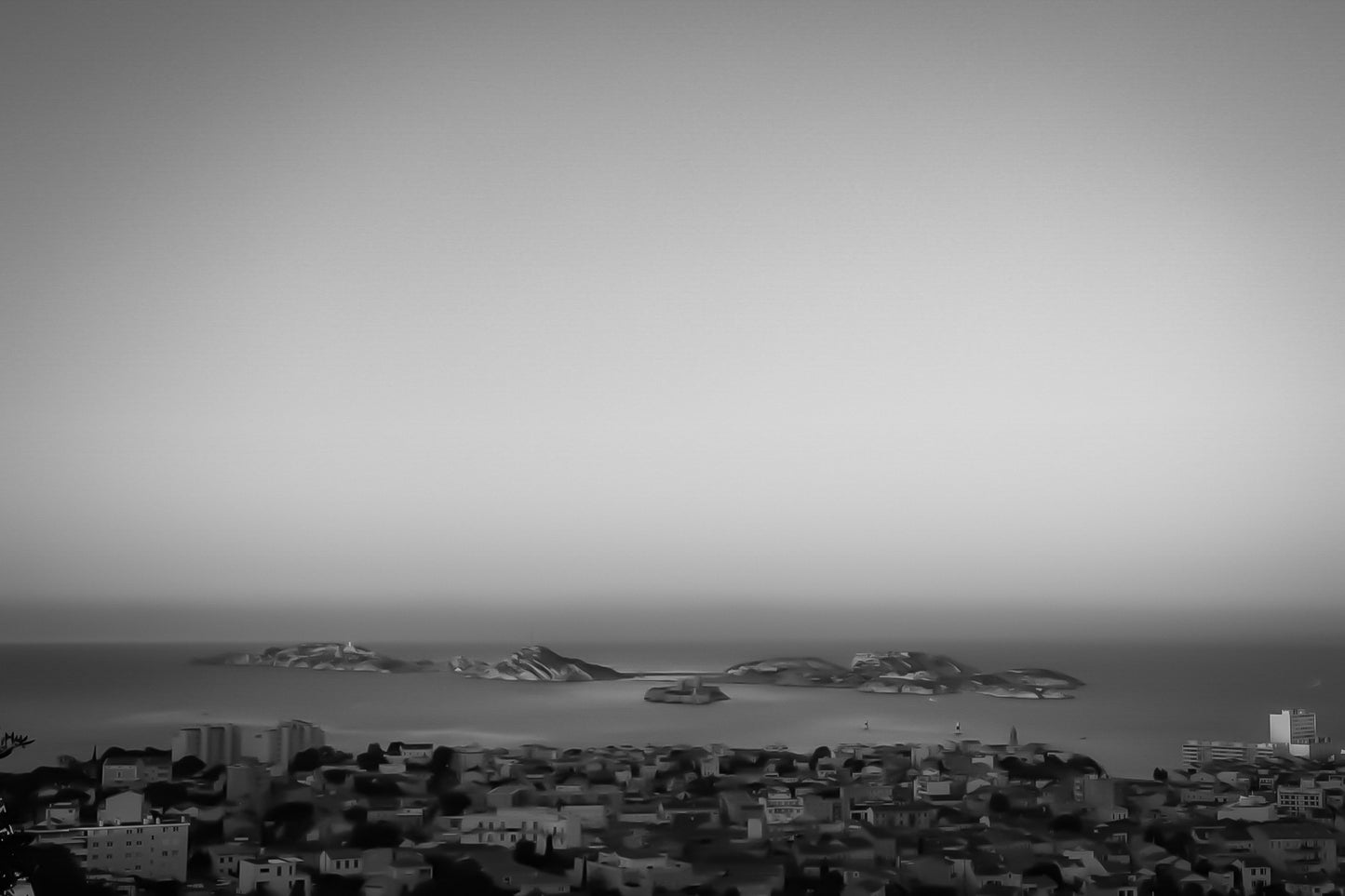 Panorama de Marseille avec les îles du Frioul et le Château d’If à l’horizon au soleil couchant, noir et blanc