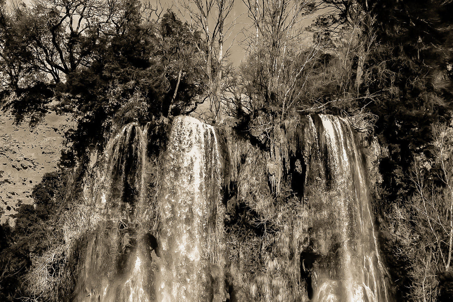 Deux pans de cascade à Sillans dévalant la falaise, entourés d’arbres nus et de mousse verte, vintage