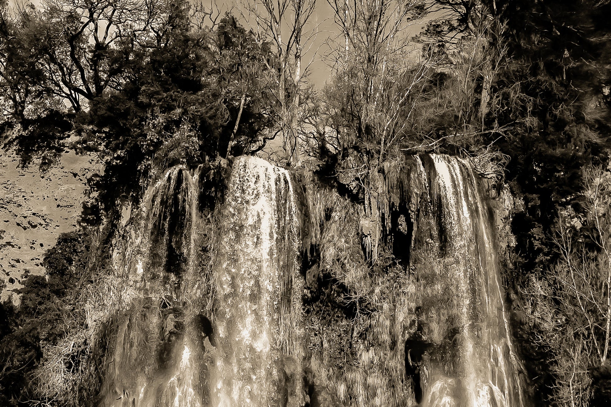 Deux pans de cascade à Sillans dévalant la falaise, entourés d’arbres nus et de mousse verte, vintage