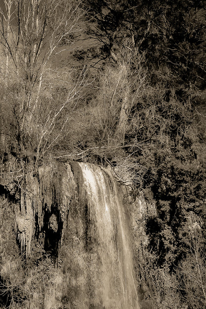 Gros plan vertical sur la cascade de Sillans avec eau ruisselante et mousses vertes accrochées à la falaise, vintage