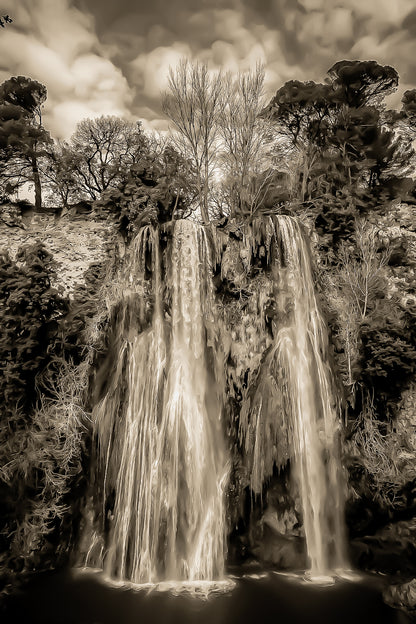 Grande cascade de Sillans se jetant dans un bassin vert émeraude entouré de falaises et de végétation, vintage