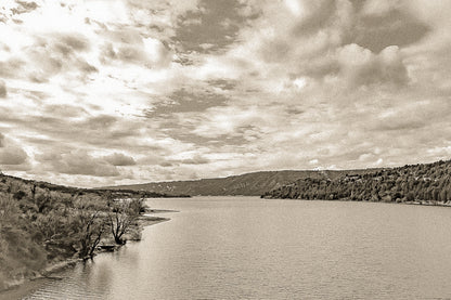 Large vue sur le lac de Sainte-Croix depuis un pont, rives boisées et grand ciel nuageux, vintage