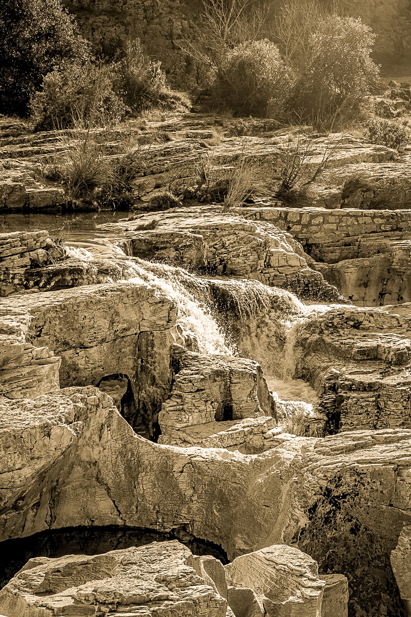 Bloc de calcaire creusé et cascade encaissée à la cascade du Sautadet, paysage minéral dominé par les rochers, vintage