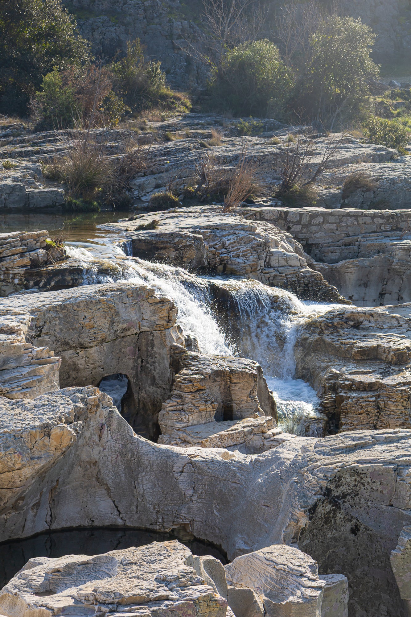 Bloc de calcaire creusé et cascade encaissée à la cascade du Sautadet, paysage minéral dominé par les rochers