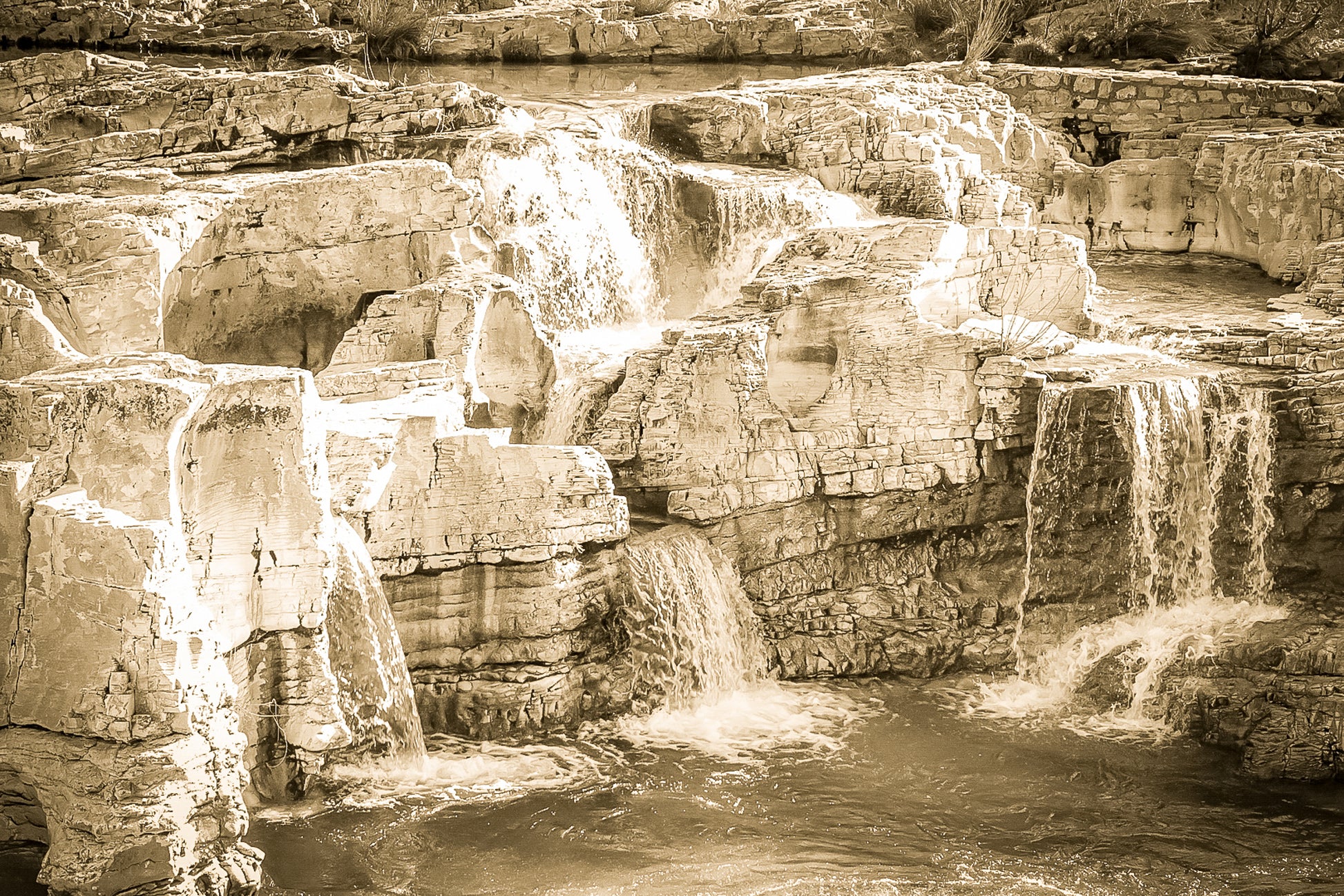 Ensemble de chutes superposées tombant dans un bassin turquoise à la cascade du Sautadet, vintage