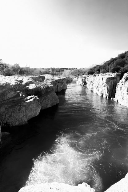 Bras de la Cèze encaissé entre deux parois calcaires, eau émeraude et remous en premier plan, noir et blanc