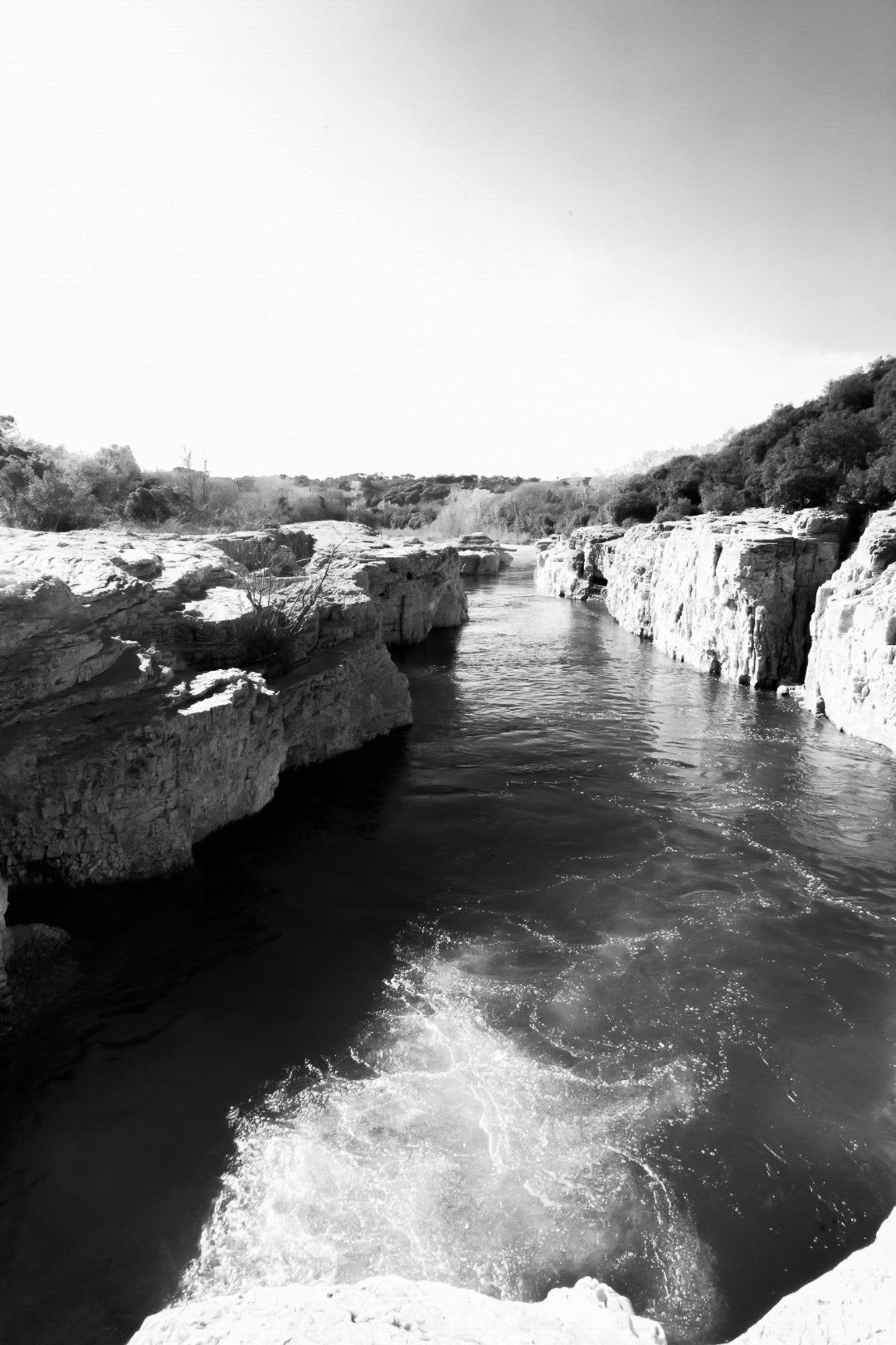 Bras de la Cèze encaissé entre deux parois calcaires, eau émeraude et remous en premier plan, noir et blanc