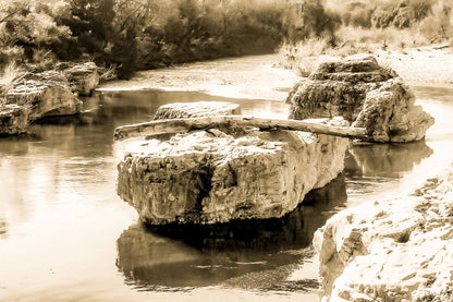 Gros rocher au milieu de la rivière Cèze avec un tronc posé en travers à la cascade du Sautadet, vintage