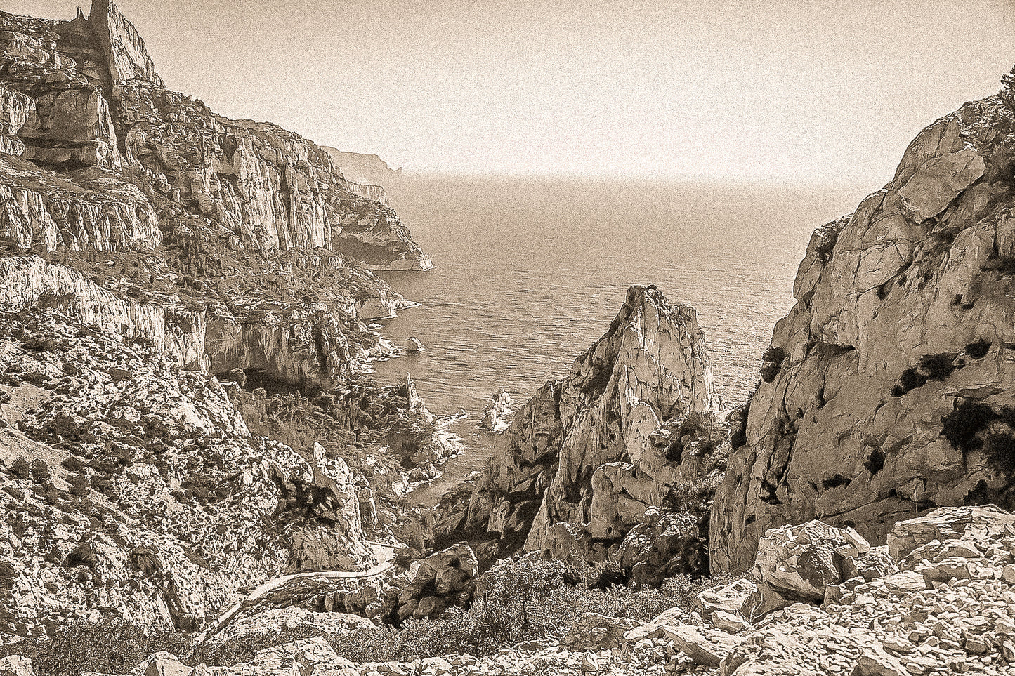 Vue plongeante entre deux parois rocheuses sur l’eau turquoise de la calanque de Sugiton, vintage