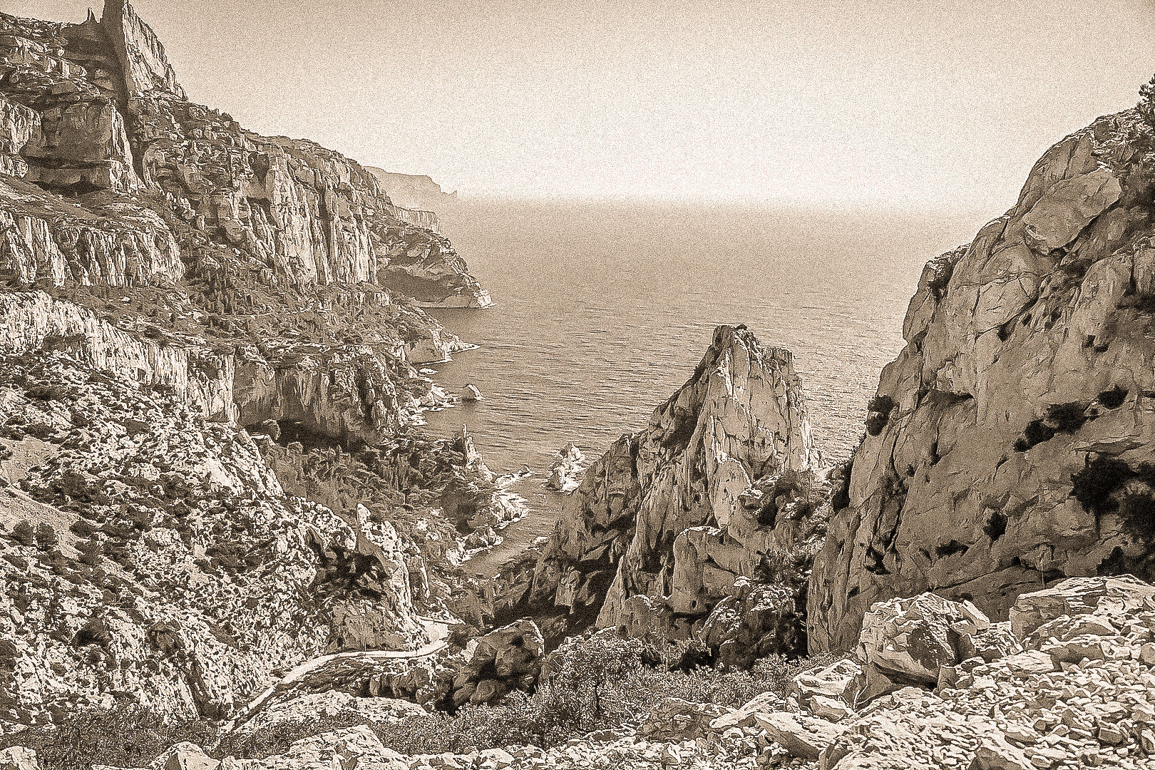 Vue plongeante entre deux parois rocheuses sur l’eau turquoise de la calanque de Sugiton, vintage