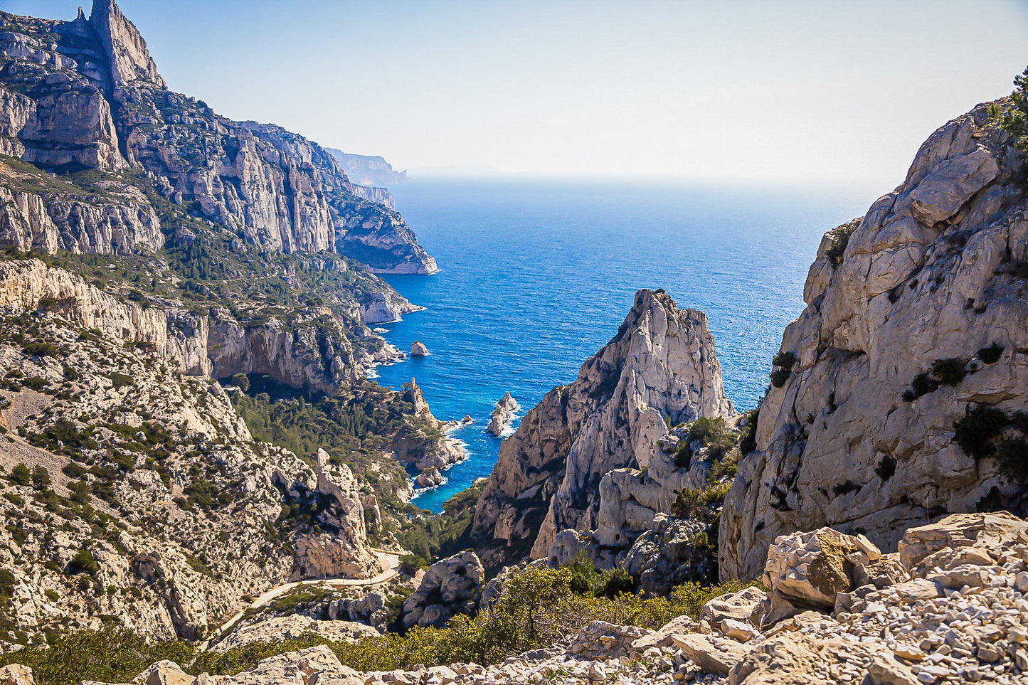 Vue plongeante entre deux parois rocheuses sur l’eau turquoise de la calanque de Sugiton