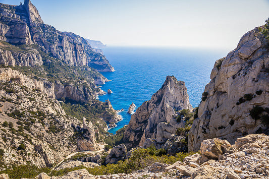 Vue plongeante entre deux parois rocheuses sur l’eau turquoise de la calanque de Sugiton