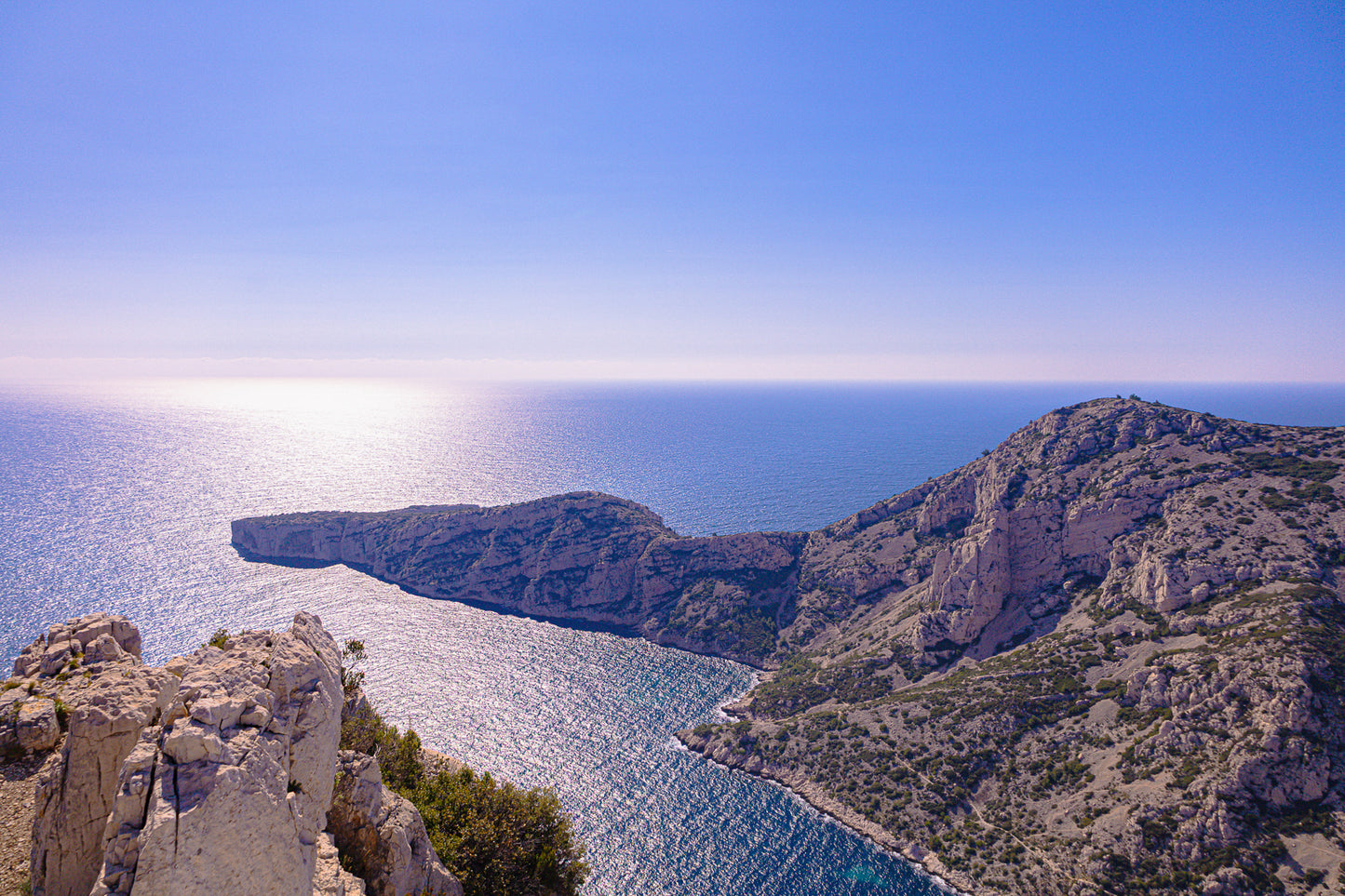 Éperon rocheux avançant dans la mer scintillante au large des calanques de Marseille