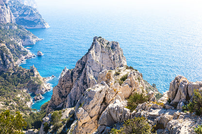 Pic calcaire élancé face à la mer, relief emblématique des calanques de Sugiton