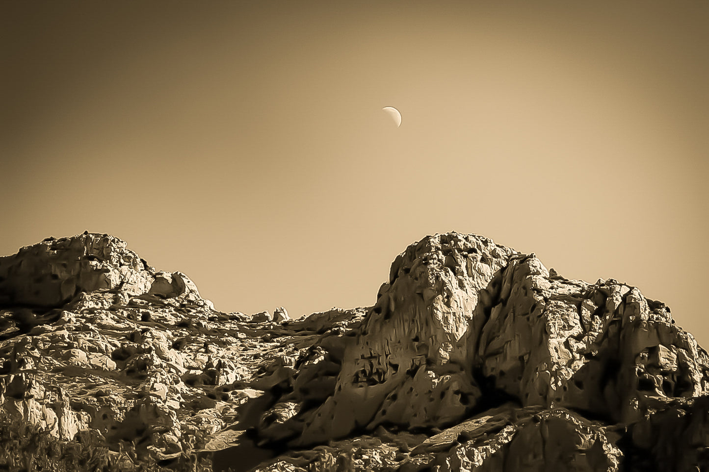 Demi-lune au-dessus des roches de Sugiton, atmosphère vintage sépia et lumière douce.