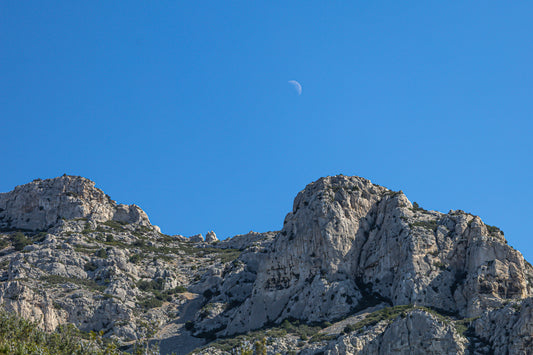 Demi-lune au-dessus des crêtes calcaires de Sugiton, ciel bleu profond et relief minéral