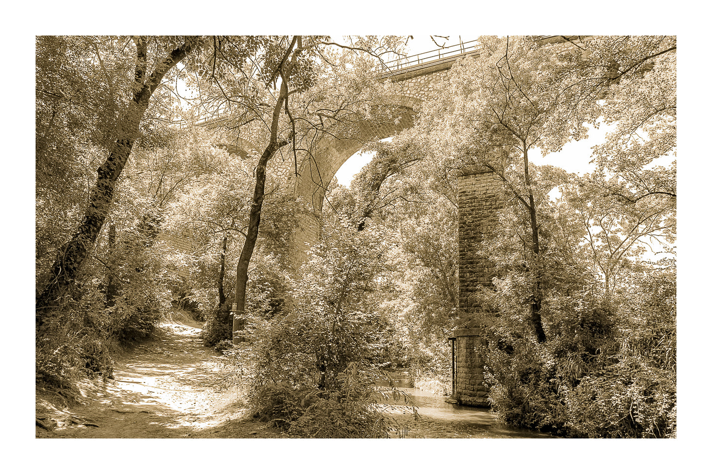 Viaduc de pierre traversant une vallée boisée au-dessus de la rivière de l’Arc, vintage avec bordure