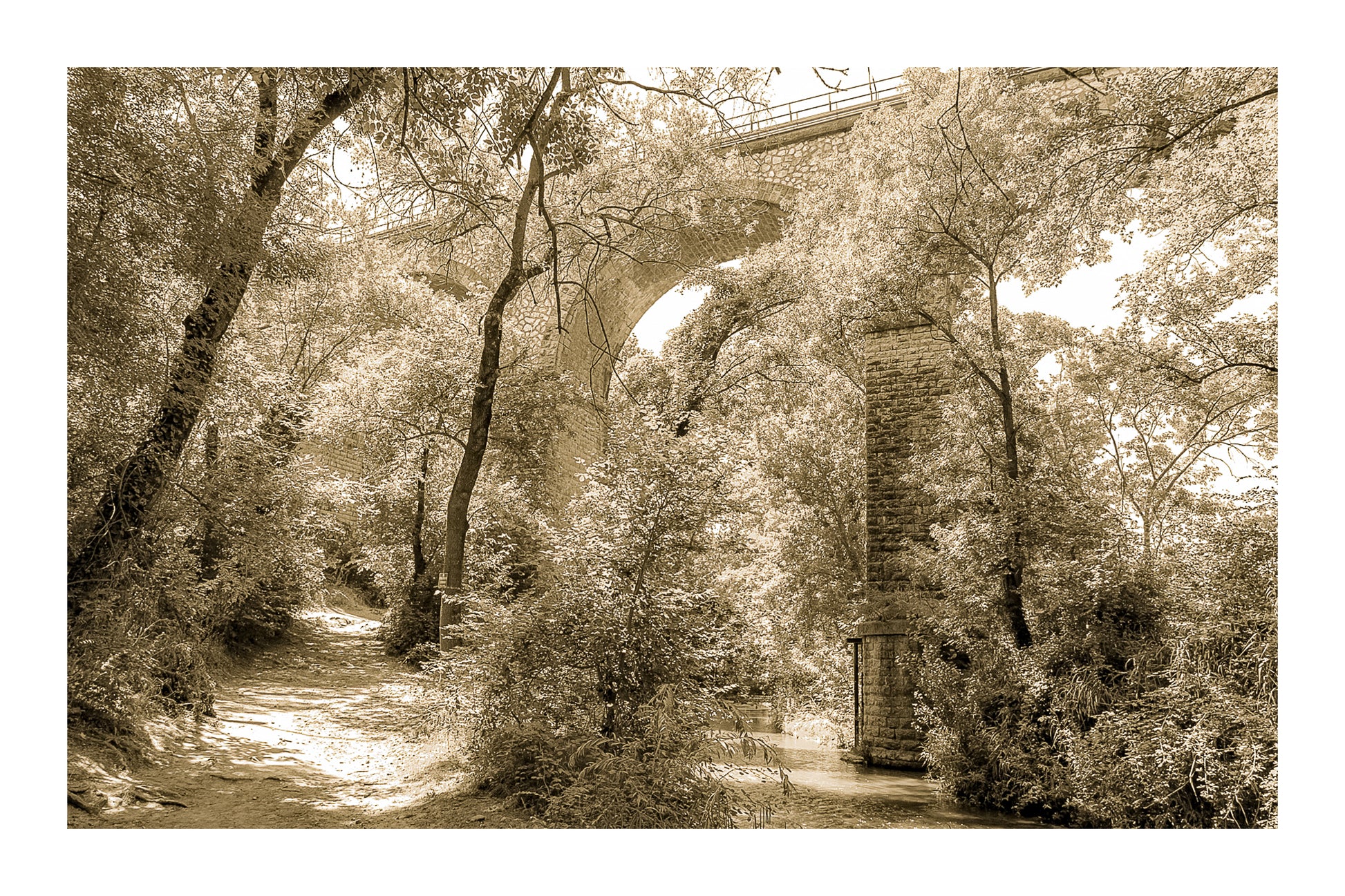 Viaduc de pierre traversant une vallée boisée au-dessus de la rivière de l’Arc, vintage avec bordure
