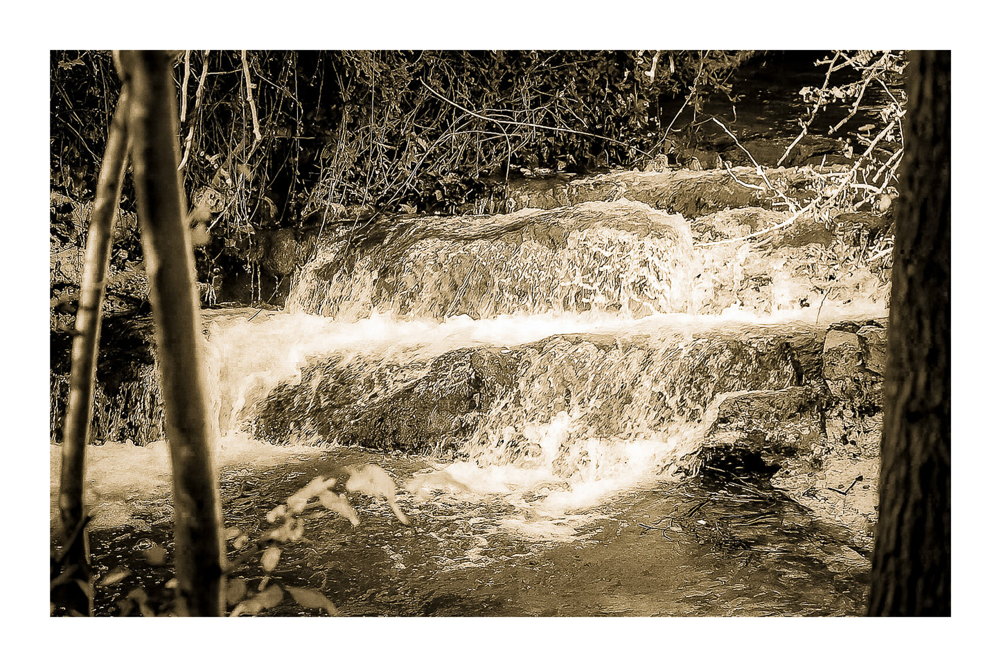 Petite cascade aux eaux émeraude sur la rivière de l’Arc entourée de végétation à Aix-en-Provence, vintage avec bordure