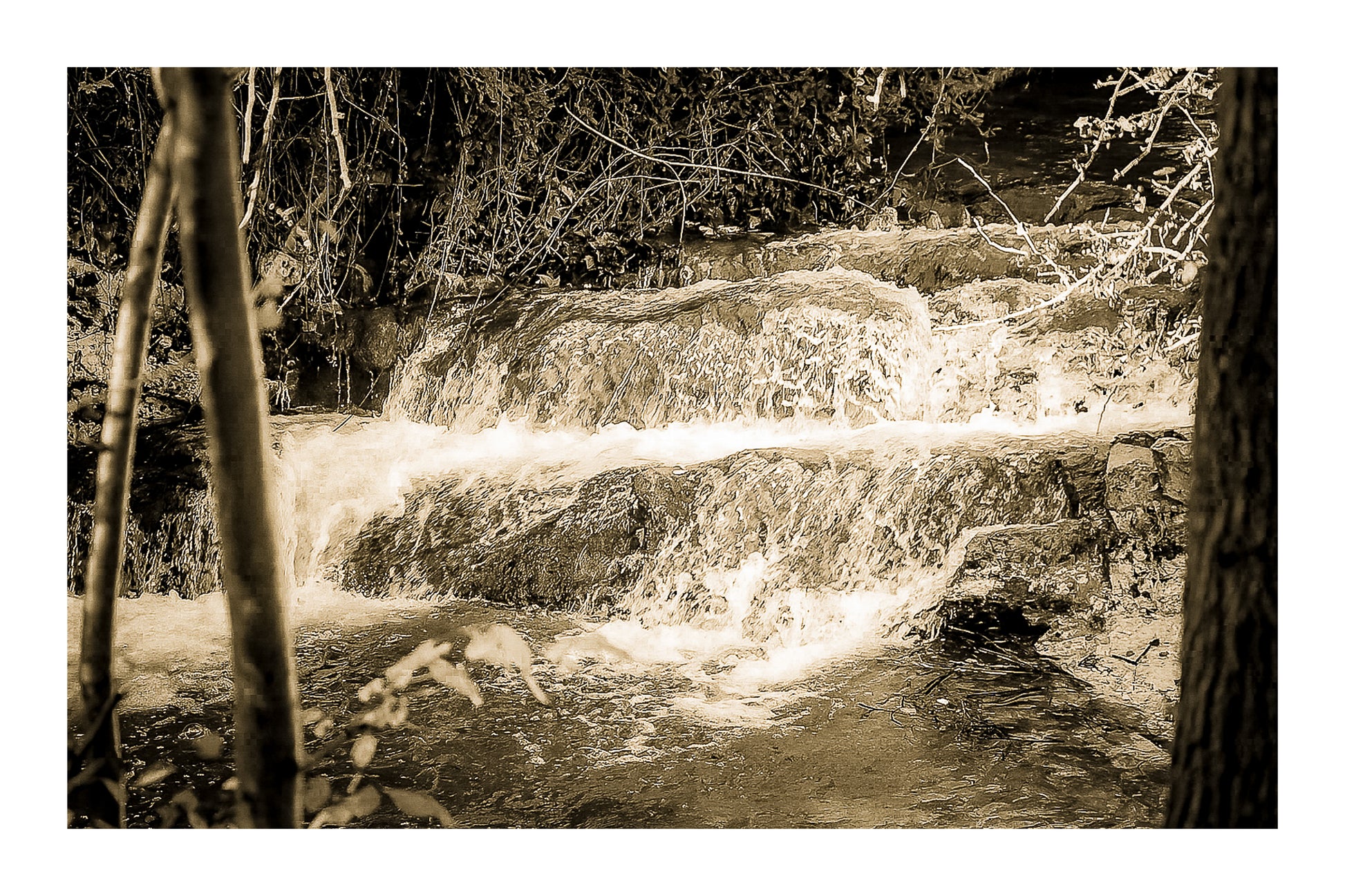 Petite cascade aux eaux émeraude sur la rivière de l’Arc entourée de végétation à Aix-en-Provence, vintage avec bordure