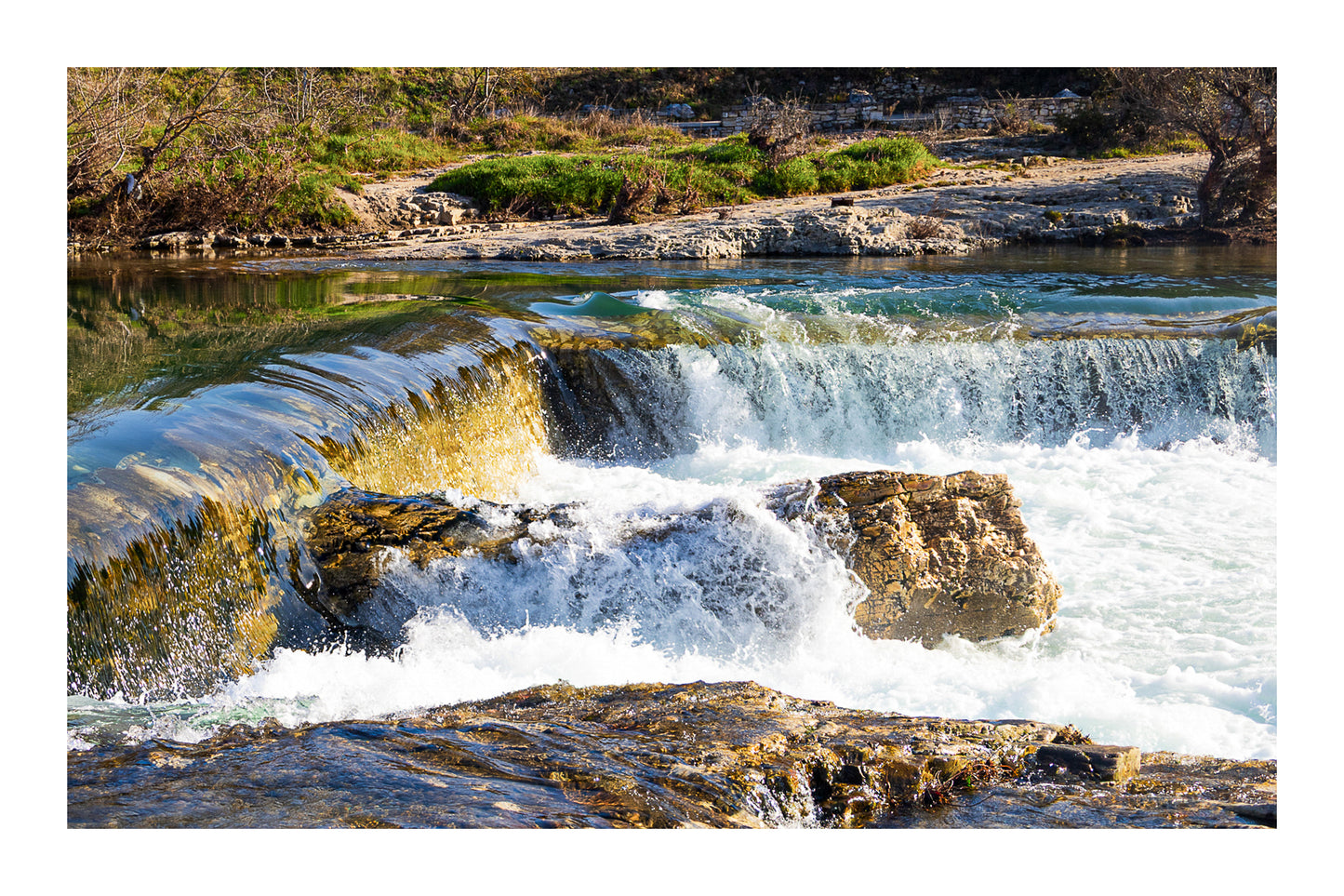 Chute de la cascade du Sautadet vue de près, rideau d’eau doré glissant sur la roche avant de se briser en écume blanche avec bordure