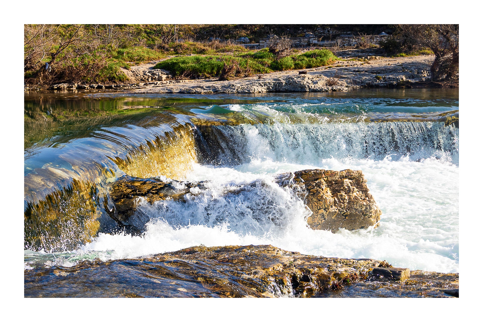 Chute de la cascade du Sautadet vue de près, rideau d’eau doré glissant sur la roche avant de se briser en écume blanche avec bordure