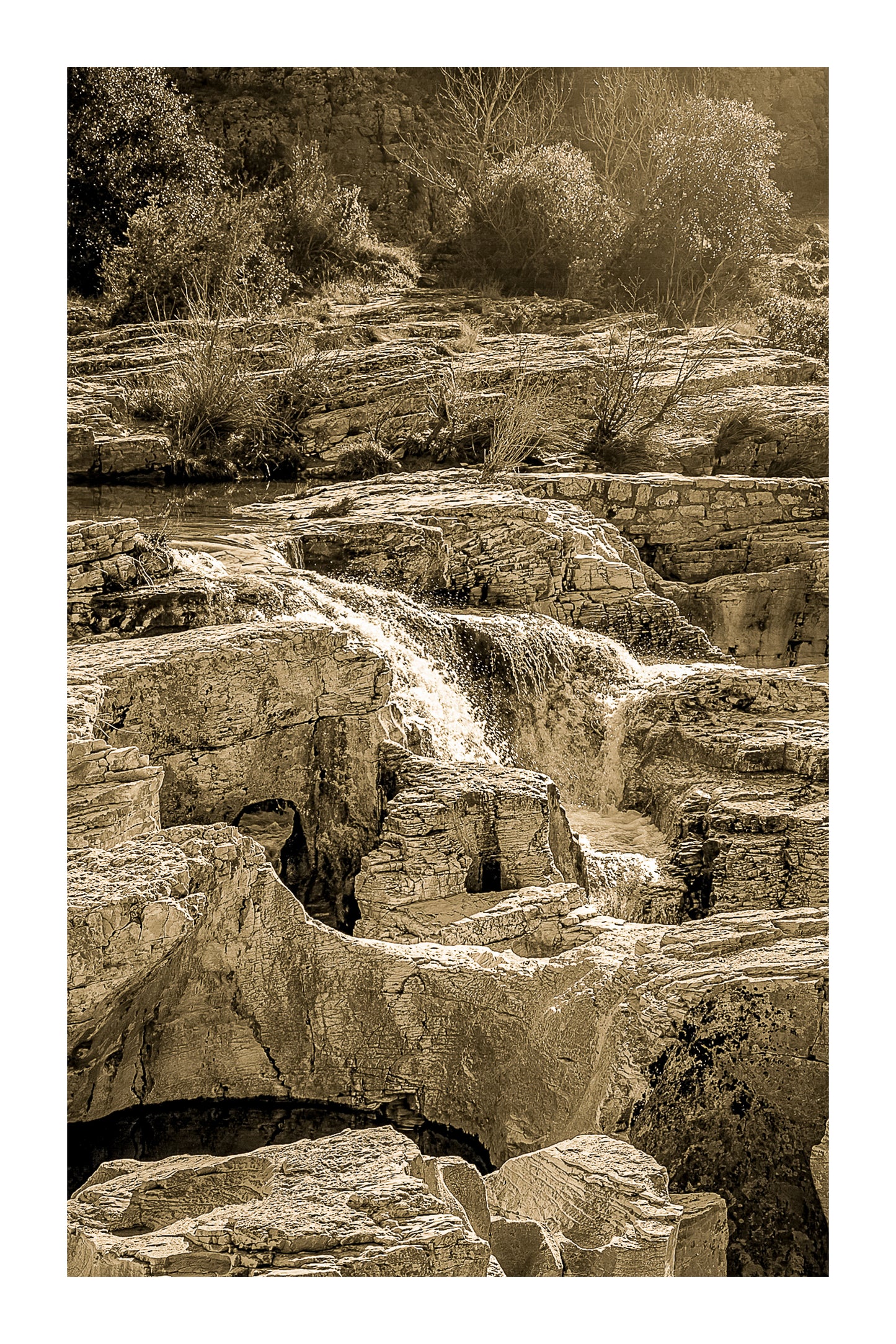 Bloc de calcaire creusé et cascade encaissée à la cascade du Sautadet, paysage minéral dominé par les rochers, vintage avec bordure
