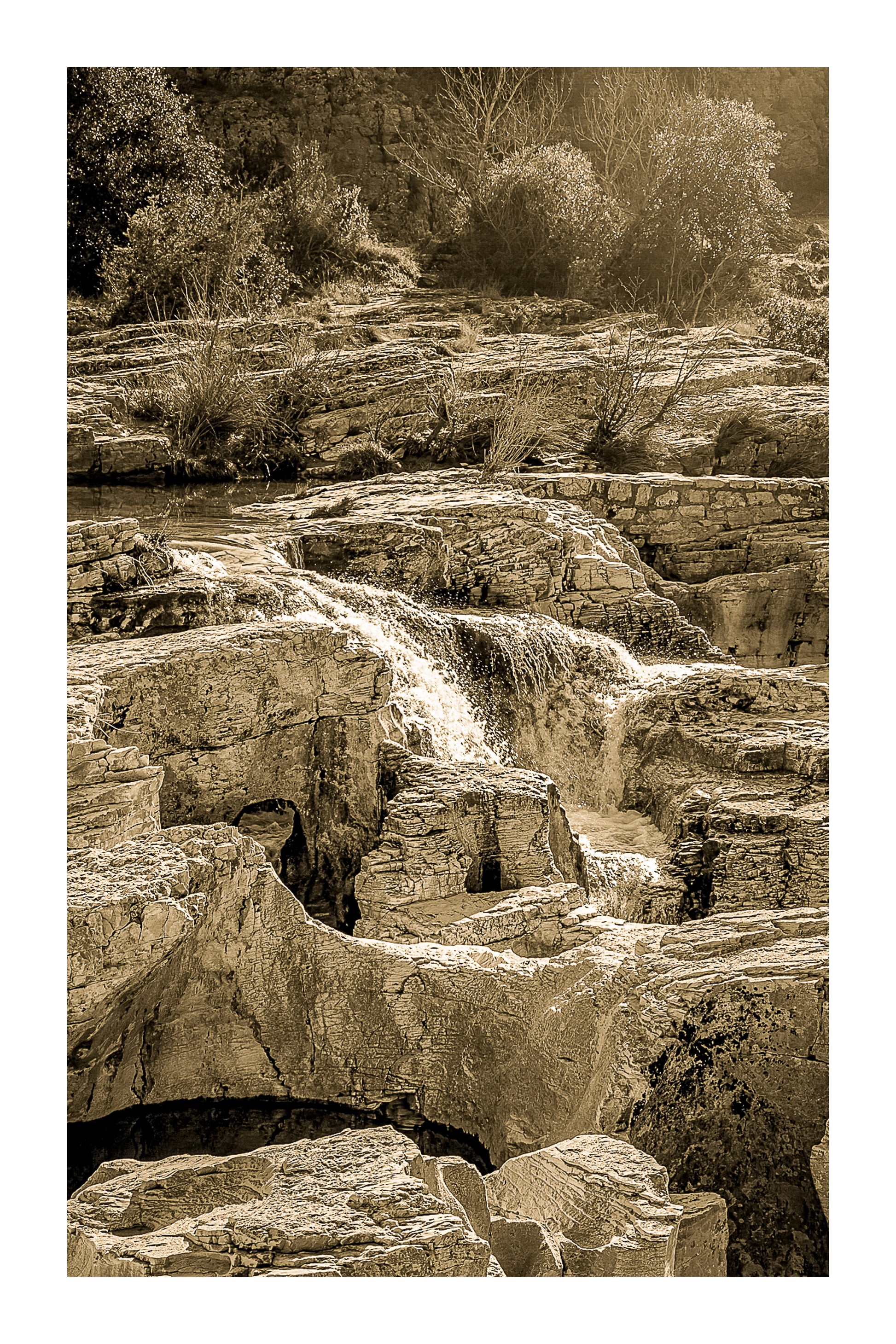 Bloc de calcaire creusé et cascade encaissée à la cascade du Sautadet, paysage minéral dominé par les rochers, vintage avec bordure