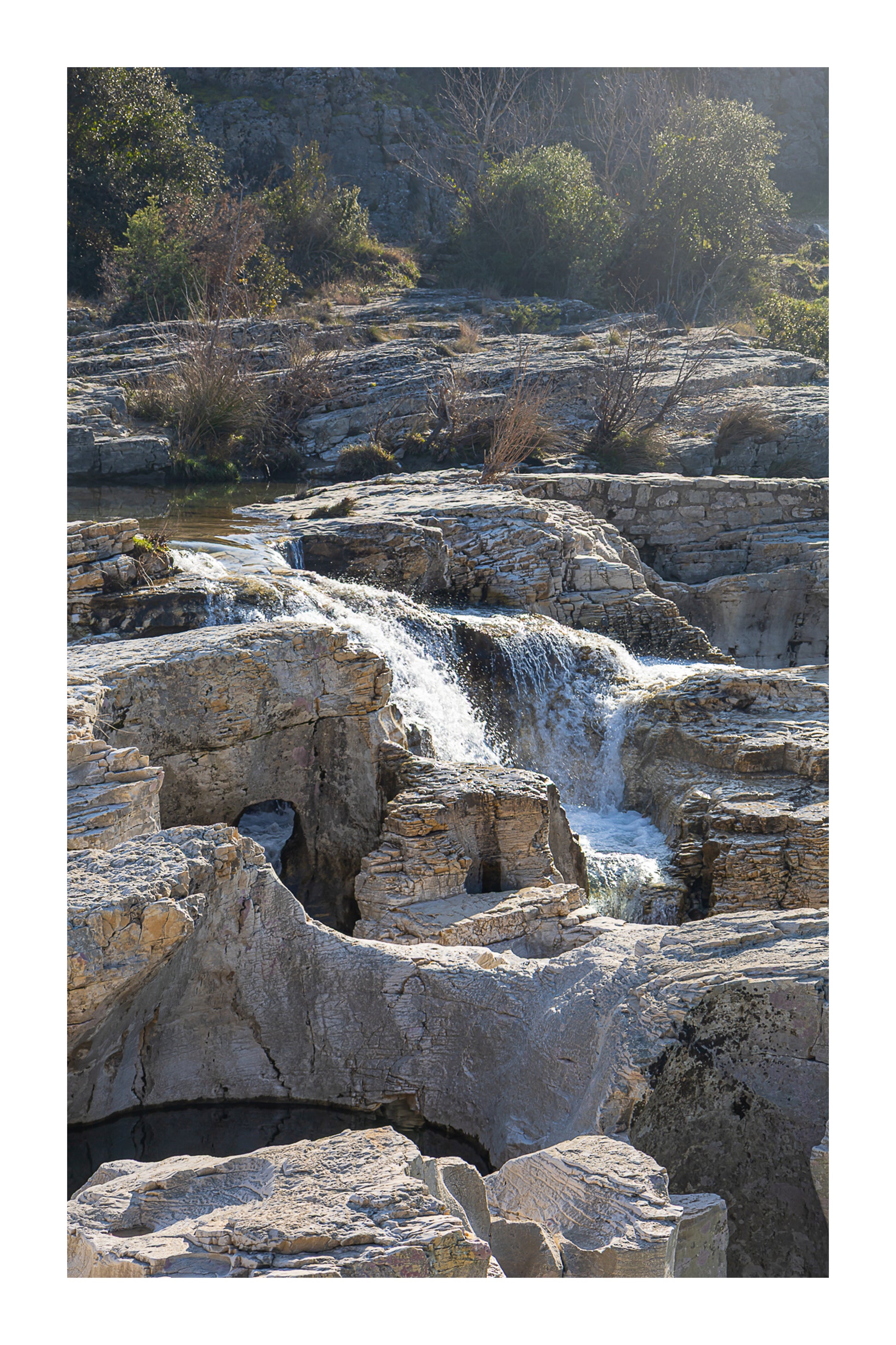Bloc de calcaire creusé et cascade encaissée à la cascade du Sautadet, paysage minéral dominé par les rochers avec bordure