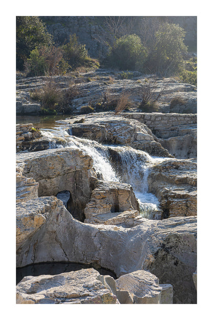 Bloc de calcaire creusé et cascade encaissée à la cascade du Sautadet, paysage minéral dominé par les rochers avec bordure