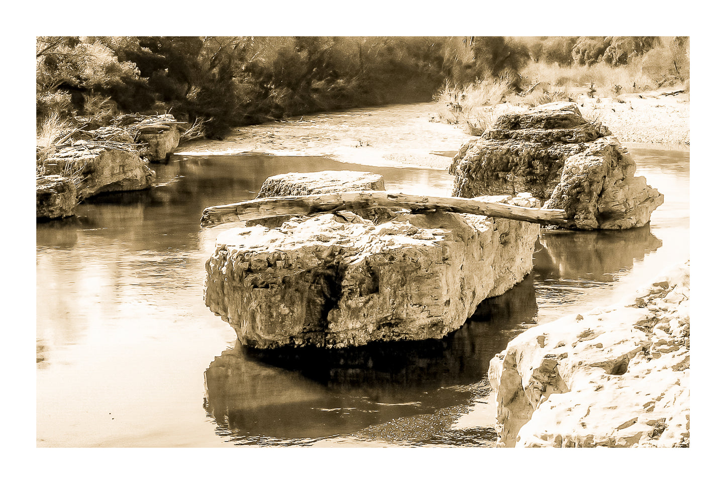 Gros rocher au milieu de la rivière Cèze avec un tronc posé en travers à la cascade du Sautadet, vintage avec bordure
