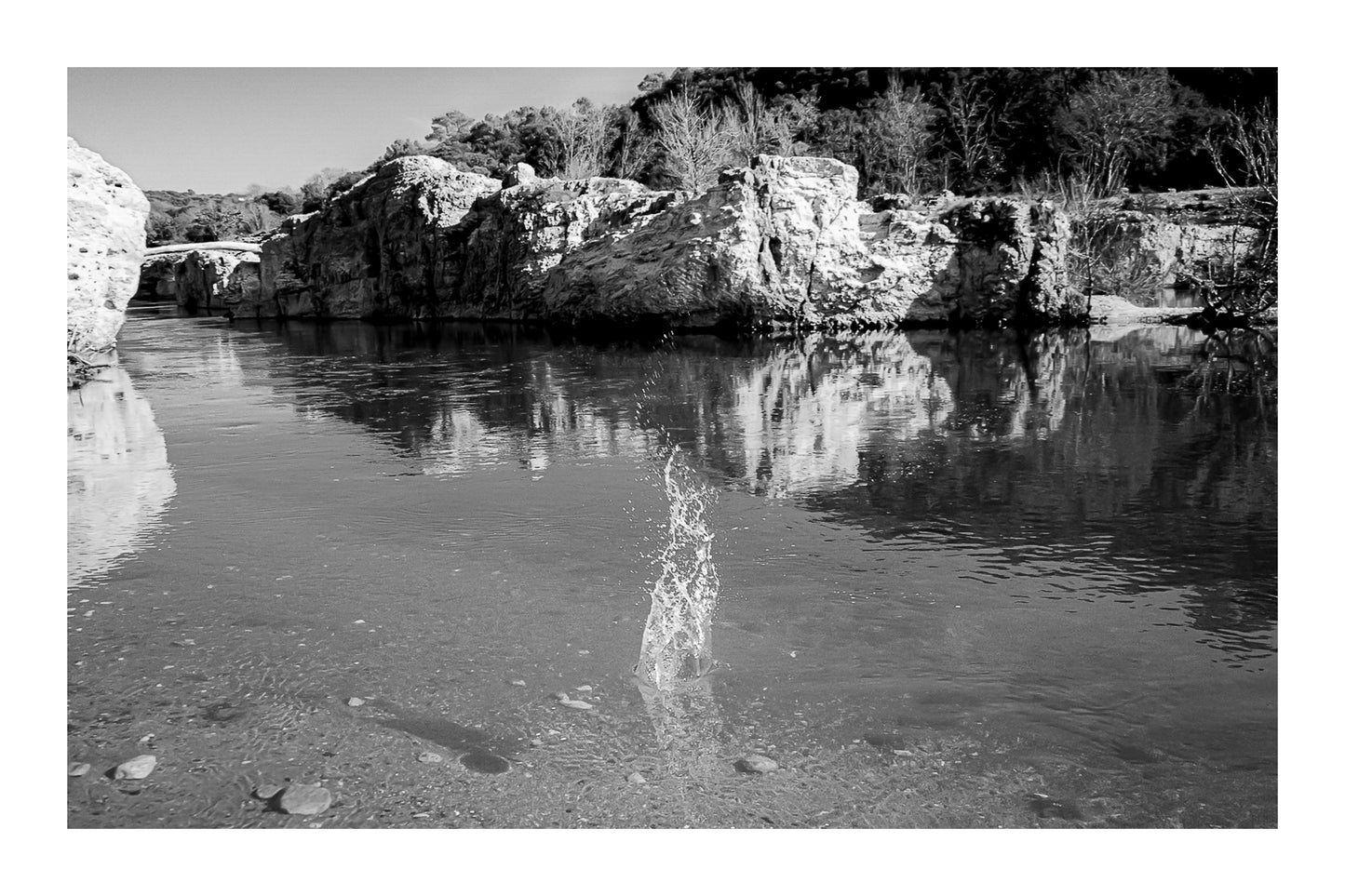 Goutte d’eau éclatant en gerbe au centre de la rivière turquoise à la cascade du Sautadet, falaises claires en reflet, noir et blanc avec bordure