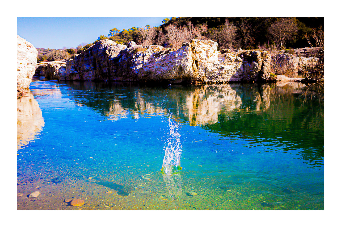 Goutte d’eau éclatant en gerbe au centre de la rivière turquoise à la cascade du Sautadet, falaises claires en reflet avec bordure